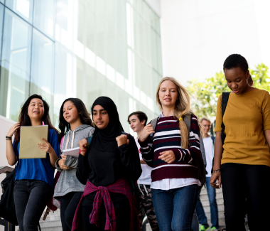 multi culti studenten leerlingen buiten lopen van trap af