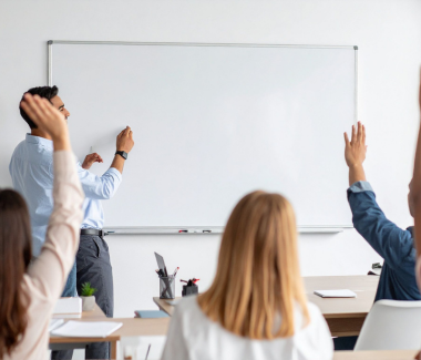 leraar bord feedback uitleg studenten leerlingen steken handen op