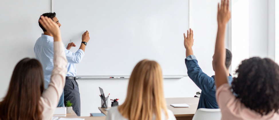 leraar bord feedback uitleg studenten leerlingen steken handen op